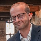 Jonge heer met pen in de hand die naar de camera kijkt