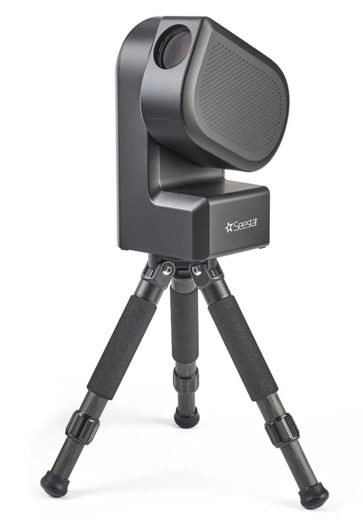 Image of a small black box-shaped telescope. The lens is attached to the side of the telescope and has rotated into view so it is clearly visible. The telescope is mounted on a small tripod.